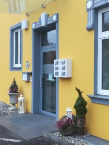 a yellow building with a blue door at Gästehaus Karl August in Fohnsdorf