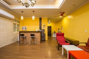 uma sala de estar com paredes amarelas e cadeiras vermelhas em N. Castle Hotel em Yilan City