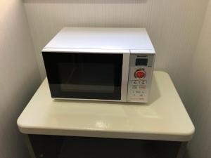 a microwave sitting on top of a white table at Iruka Hotel in Shari