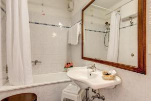 uma casa de banho com um lavatório, um espelho e uma banheira em Hotel S.Giorgio & Olimpic em Florença