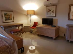 a room with a bedroom with a desk and a television at Shanti Nivas in Post of Flacq