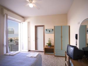een slaapkamer met een bed, een tv en een raam bij Hotel Telstar in Rimini