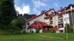 a large building with a red roof at Papa Moose Pamporovo in Pamporovo