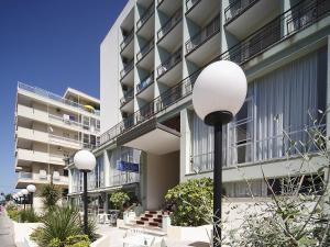 un bâtiment avec deux feux de rue devant lui dans l'établissement Hotel Telstar, à Rimini