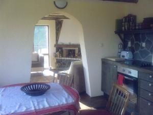 a room with a kitchen and a table with a bowl on it at Zinca's Cottage in Ogled
