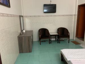 a room with two chairs and a table and a television at Minh Tuan Hotel in Ho Chi Minh City