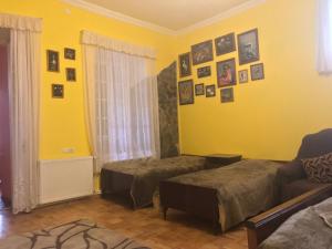 Cette chambre comprend 2 lits et un mur jaune. dans l'établissement Gamsakhurdia Street, à Bordjomi