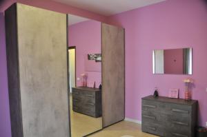a pink bathroom with two dressers and a mirror at RomAmoR in Rome +6 photos