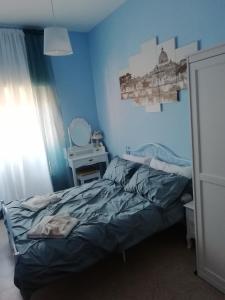 a blue bedroom with a bed and a mirror at RomAmoR in Rome