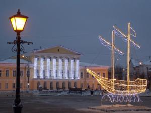 een verlichte boot voor een gebouw 's nachts bij Art-Hotel Centralnyi in Kostroma