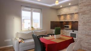 eine Küche und ein Wohnzimmer mit einem Tisch und einem Sofa in der Unterkunft Apartament Lublin Centrum "Foxy Cat" in Lublin