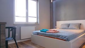 a bedroom with a bed with a chair and a window at Apartament Lublin Centrum "Foxy Cat" in Lublin