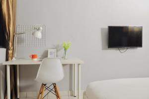 a bedroom with a desk and a bed and a tv at GRAYHAUS Residence in Petaling Jaya
