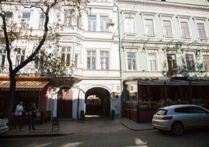 a white building with a car parked in front of it at Soprano Apart Hotel in Odesa