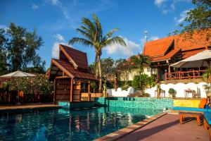 Haad Chao PhaoZama Resort Koh Phangan的一座带房子和度假胜地的游泳池