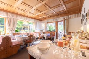 ノーヴァ・レヴァンテにあるハウス クリスチャンの白いテーブルと椅子、窓のあるレストラン