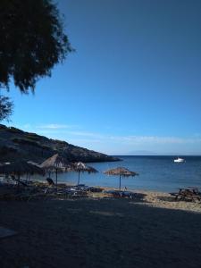a beach with umbrellas and a boat in the water at LYGIROS ANASTASIOS in Tarti