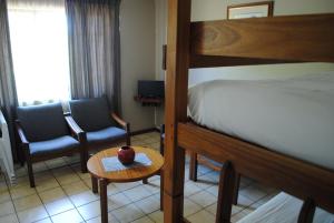 a bedroom with a bed and a table and a chair at Eagles Nest Chalets in Hazyview