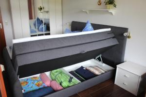 ein Schlafzimmer mit einem grauen Bett mit einer Schublade in der Unterkunft Ferienwohnung Schluchsee in Schluchsee