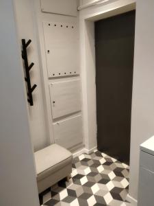 a bathroom with a closet with a toilet and a checkered floor at Apartament Mazowiecka 125 in Krakow