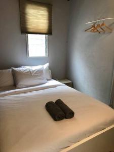 GRAYHAUS Residence في بيتالينغ جايا: غرفة نوم عليها سرير وفوط