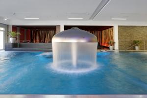 una piscina de agua en medio de una habitación en Parkhotel CUP VITALIS, en Bad Kissingen