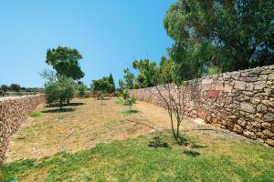 un muro di pietra con alberi di fronte di Villa Valletta a Żejtun