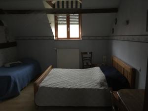 een slaapkamer met 2 bedden en een raam bij gite du chêne in Bierne