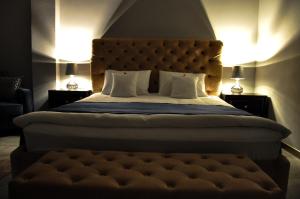 - une chambre avec un grand lit et une grande tête de lit dans l'établissement Rubio Residence - Accmonia Luxury Apartment, à Arad