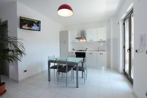 a kitchen and dining room with a glass table and chairs at Il Gabbiano - Case Vacanze in Capo dʼOrlando