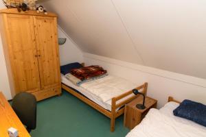 ブレスケンスにあるHello Zeeland - Vakantiehuis Zwin 174のベッド2台とキャビネット付きの小さな部屋です。