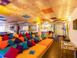 a room with a long couch filled with colorful pillows at goSTOPS Rishikesh, Tapovan in Rishīkesh