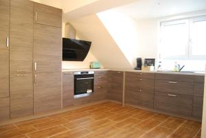 a kitchen with wooden cabinets and a tv at Luxus Loft ideal Europa Park, Straßburg und Schwarzwald in Friesenheim