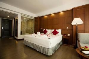 um quarto com uma grande cama branca com almofadas vermelhas em Himalayan Front Hotel by KGH Group em Pokhara