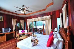 ハード・ヤオにあるHaad Yao Bayview Resort & Spa - SHA plus Certifiedのベッドルーム1室(ベッド1台付)、リビングルームが備わります。