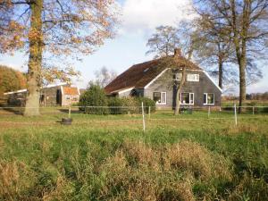 an old house in the middle of a field at boerderijkamer Korenbloem in Onstwedde