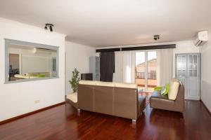 a living room with a couch and a large window at Casa dos Avós by Rent2U, Lda in Funchal