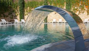 une fontaine au milieu d'une piscine dans l'établissement Cramim by Isrotel Exclusive, à Qiryat ‘Anavim