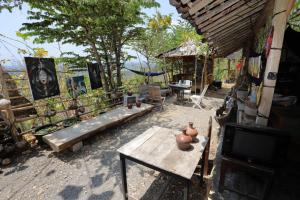 patio con mesa de madera y TV en NewAlasKuliner & HomestayWatulumbung, en Yogyakarta