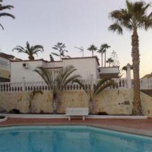 una piscina frente a un edificio con palmeras en Bungalow Isla Margarita, en Puerto Rico de Gran Canaria