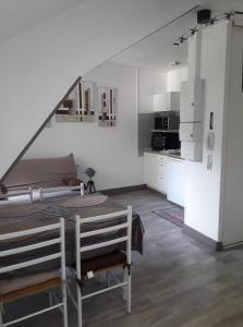 a white room with a table and a kitchen at Résidence du Baliran in Luchon