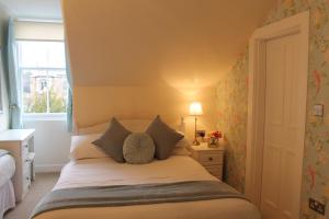 a bedroom with a white bed with a window at Sonas Guesthouse in Edinburgh