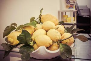 un tazón blanco lleno de limones sobre una mesa en B&B La Casa Di Plinio, en Pompeya