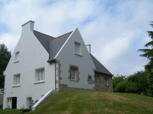 een groot wit huis bovenop een heuvel bij la vallee in Plogoff