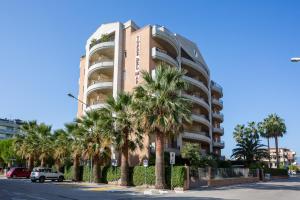 un edificio alto con palme di fronte di Residence Torre Del Mar ad Alba Adriatica