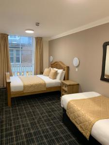 a hotel room with two beds and a window at Waverley Inn Lodge in Dingwall