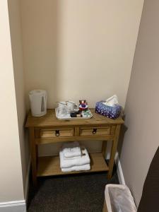 a small wooden table with towels on it at Royal Guest House in Dingwall +50 photos
