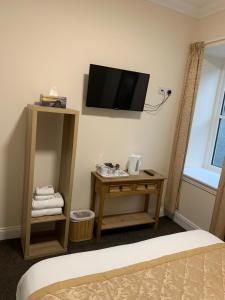 a room with a bed and a tv on the wall at Royal Hotel in Dingwall