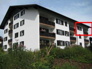 a white apartment building with a red arrow pointing to it at Fewo mit malerischem Bergblick im in Bischofsmais