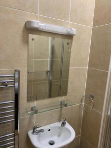 a bathroom with a sink and a mirror at Royal Guest House in Dingwall